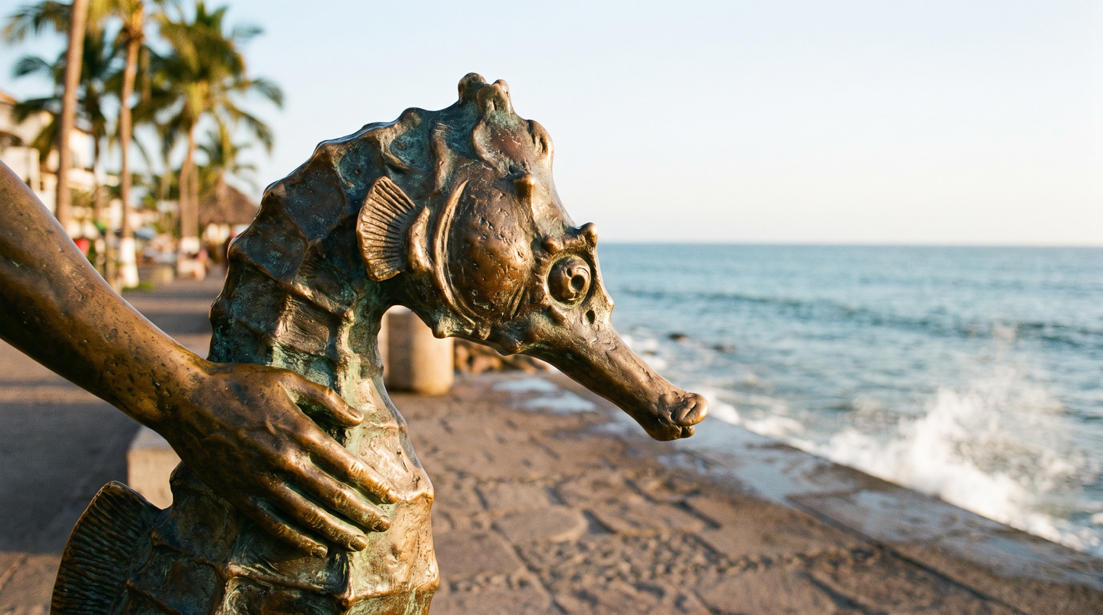 The Malecón boardwalk in Puerto Vallarta at sunset with sculptures along the promenade